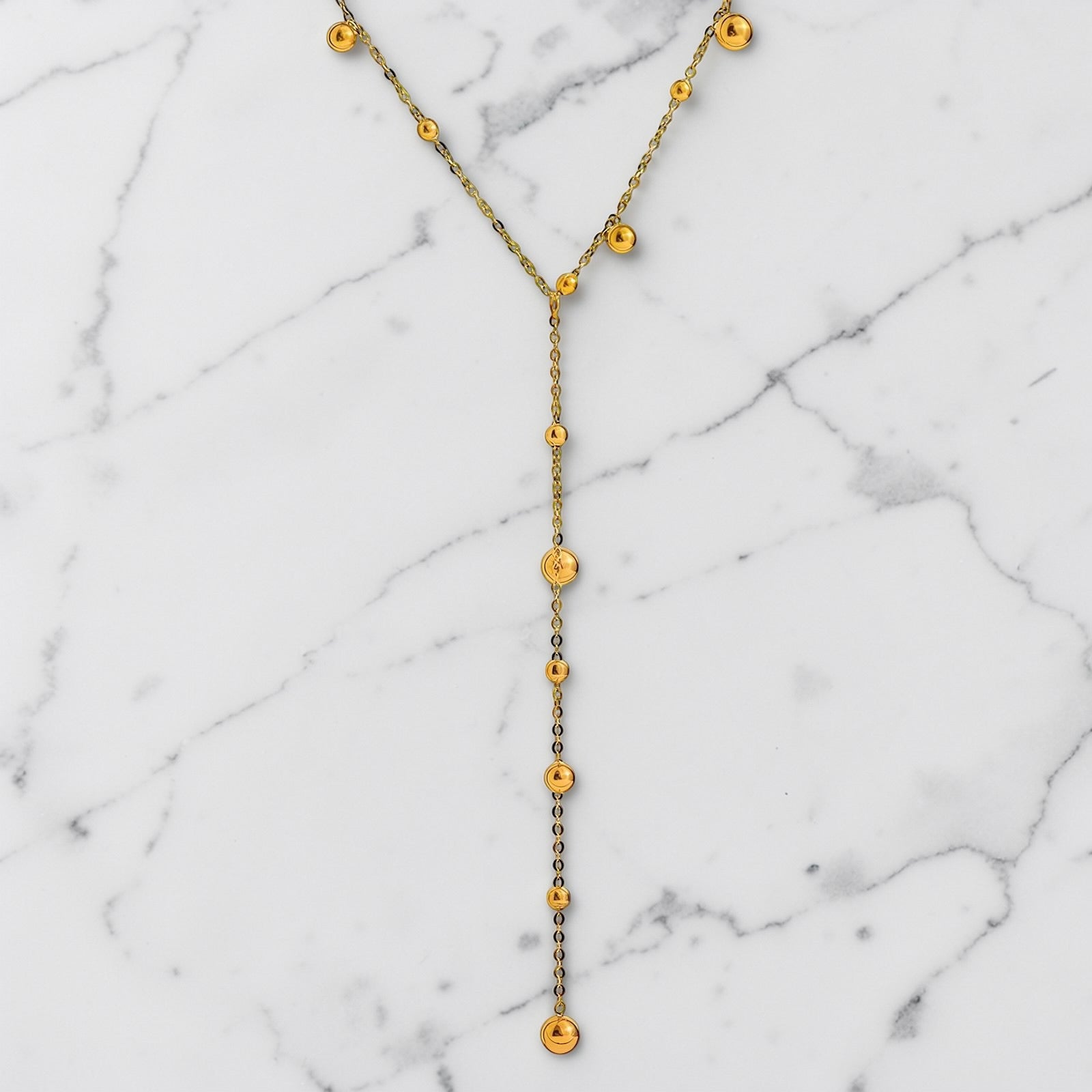 Gold-toned lariat necklace with delicate bead accents and a slim Y-shaped drop design.