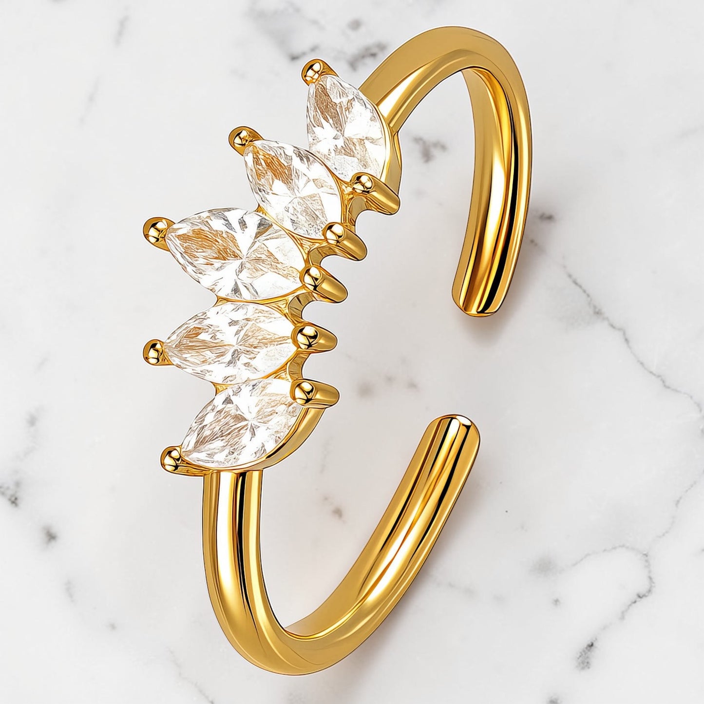 Gold open band ring with marquise-cut clear stones arranged in a sleek row