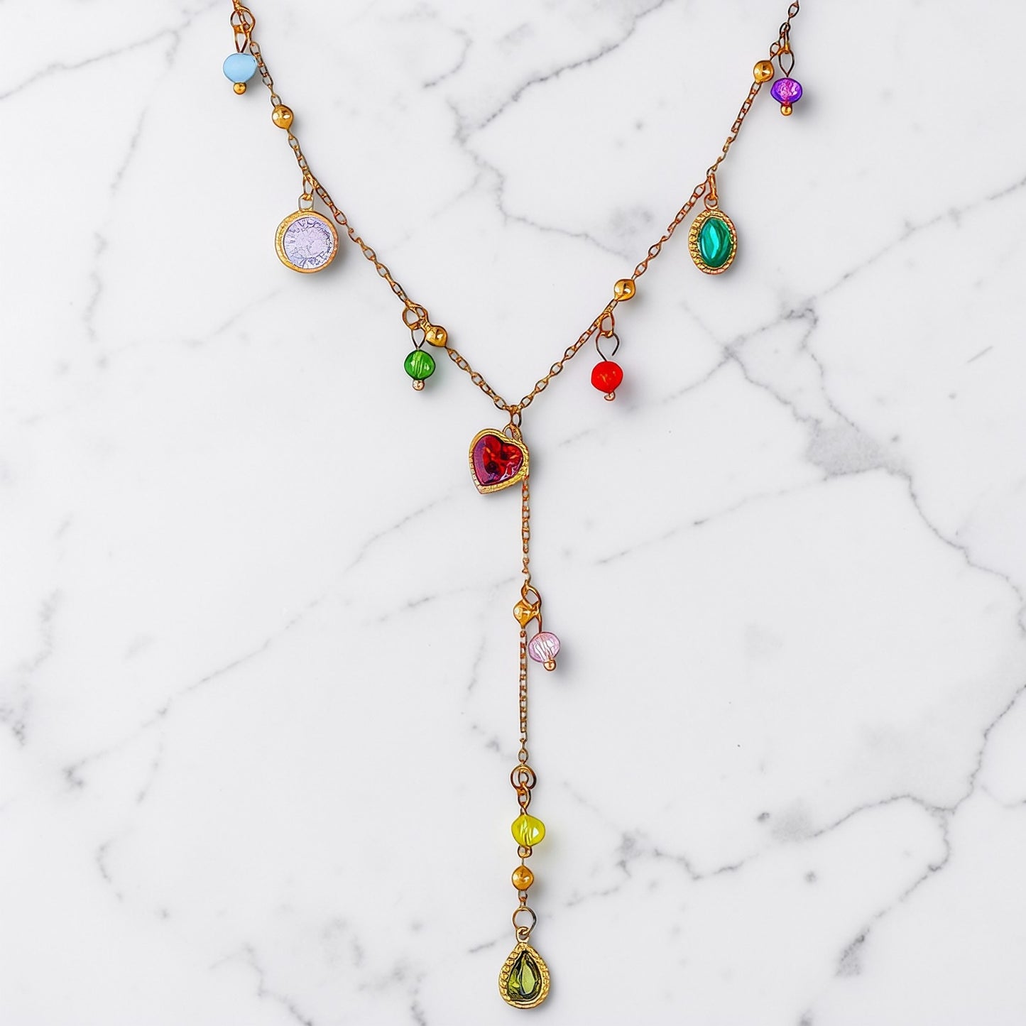 Gold charm necklace with colorful gemstone-inspired accents and a cascading drop detail