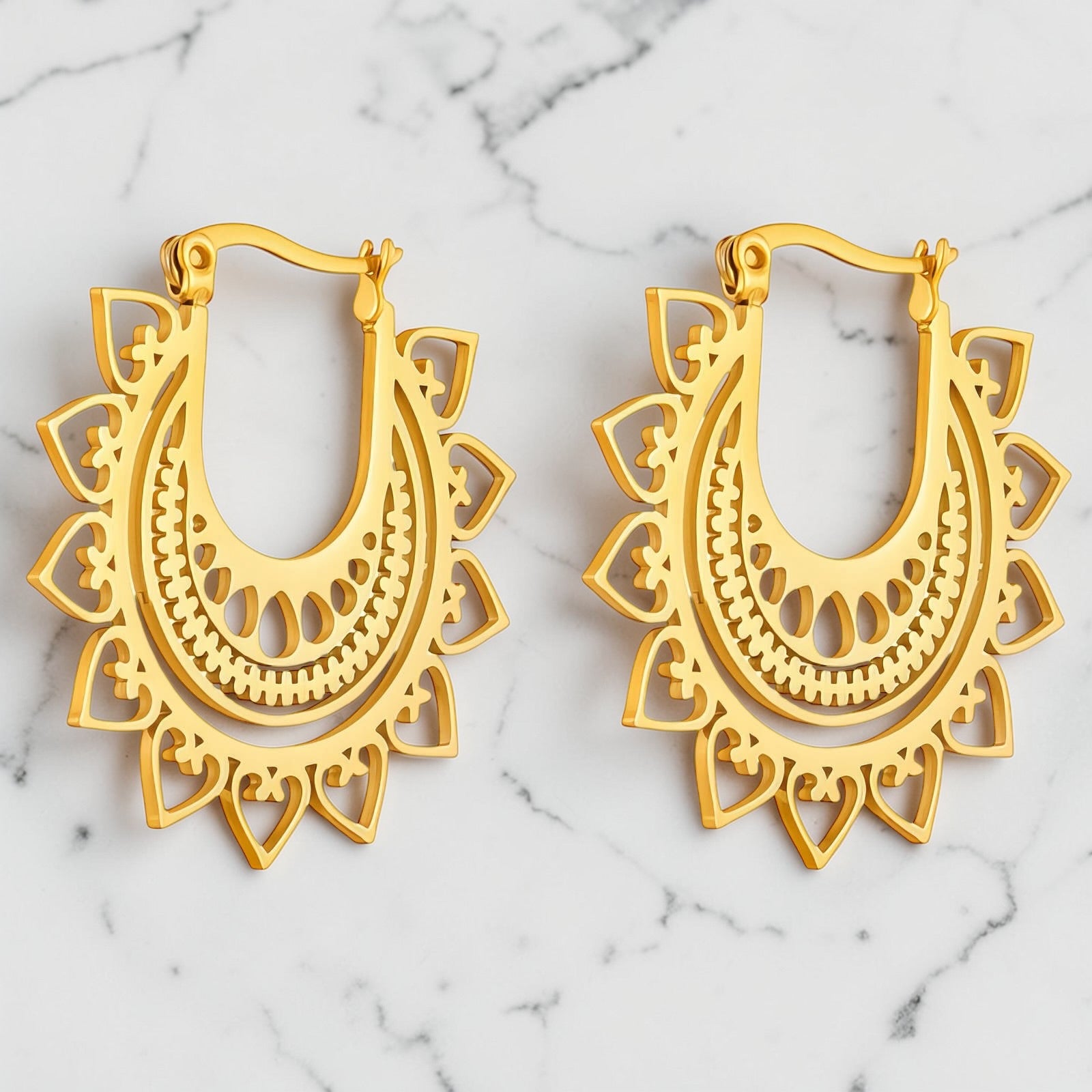 Gold hoop earrings with intricate sunburst-inspired openwork detailing.