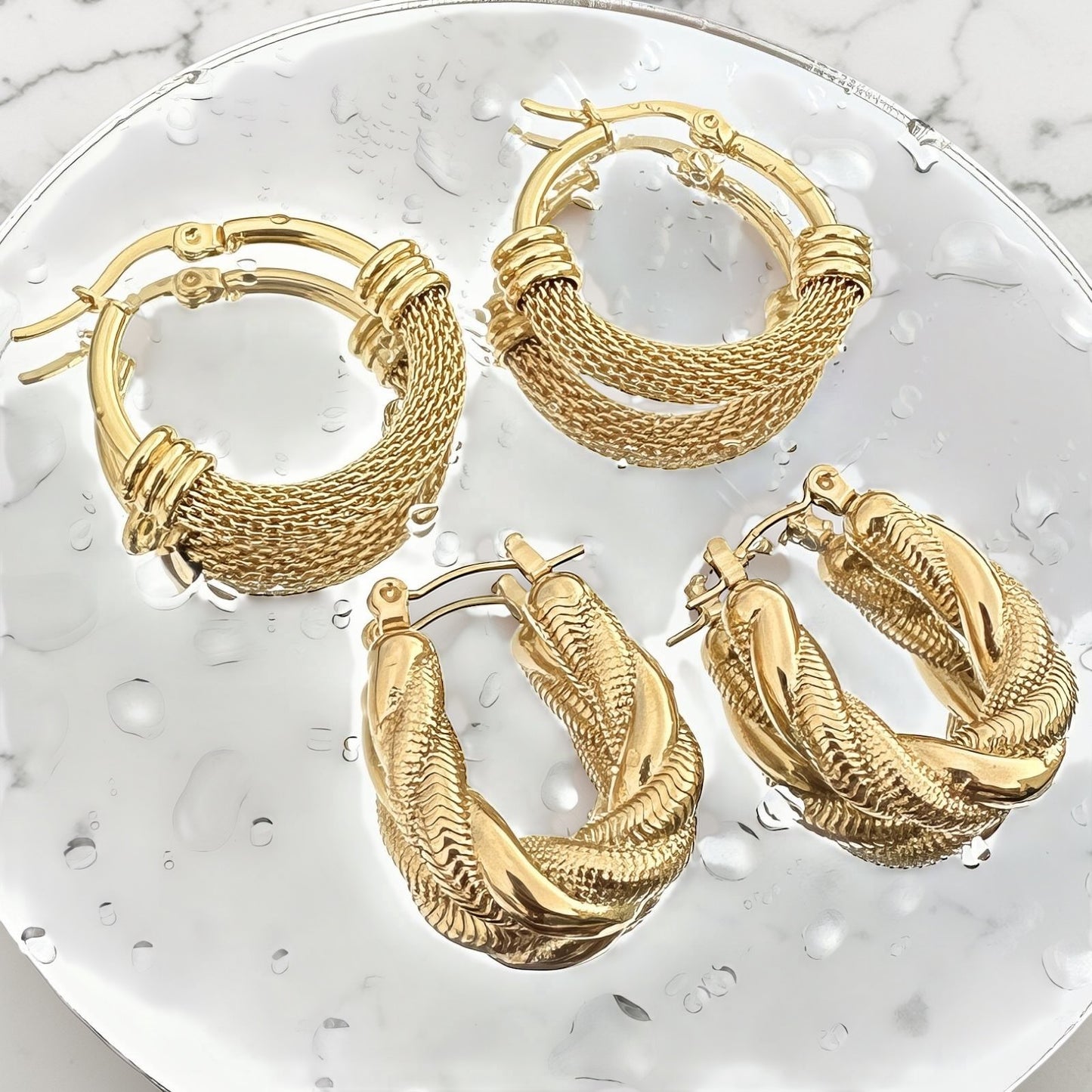 Gold twisted rope hoop earrings with textured detailing and hinged closure