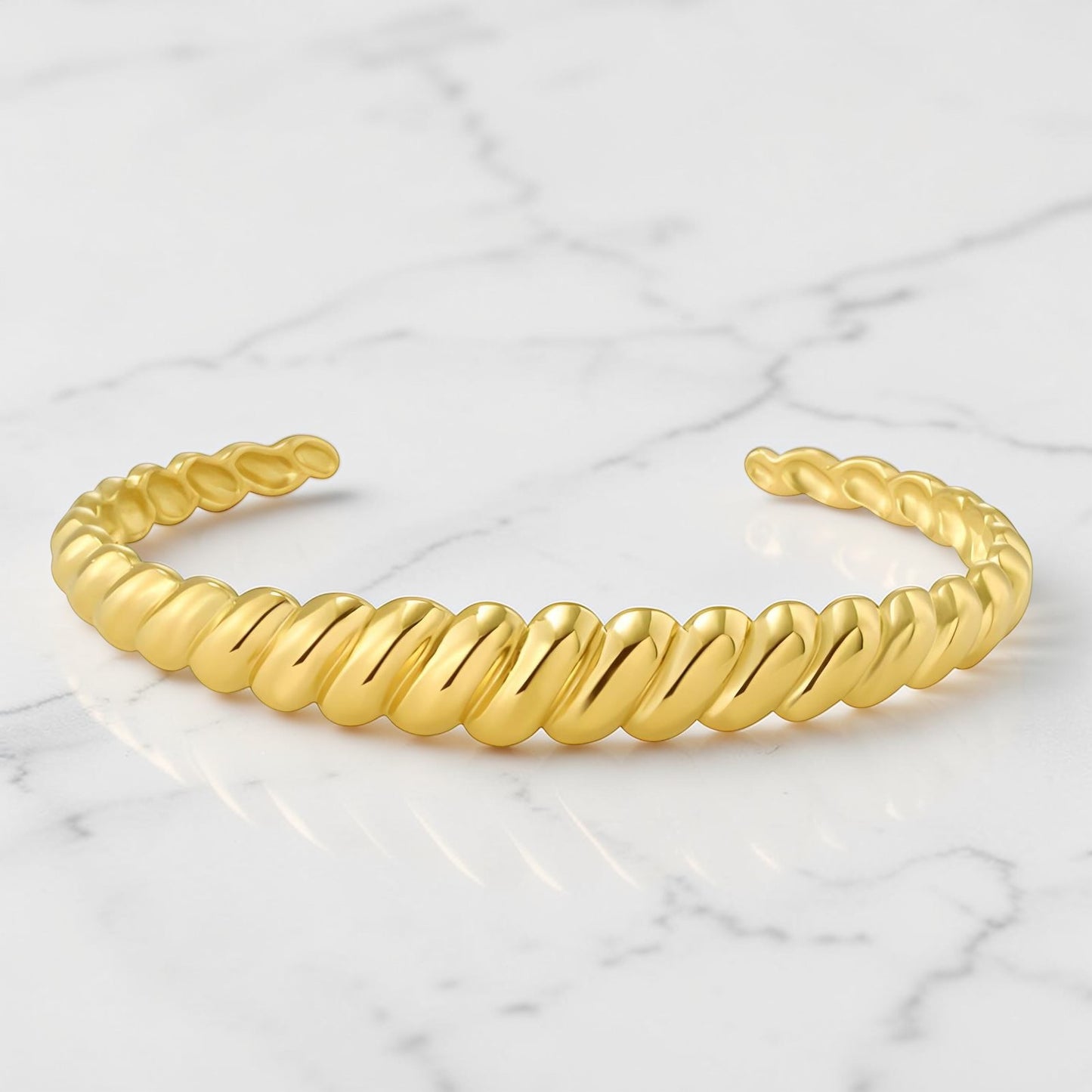Gold twisted rope-style cuff bracelet with a polished open-ended design.