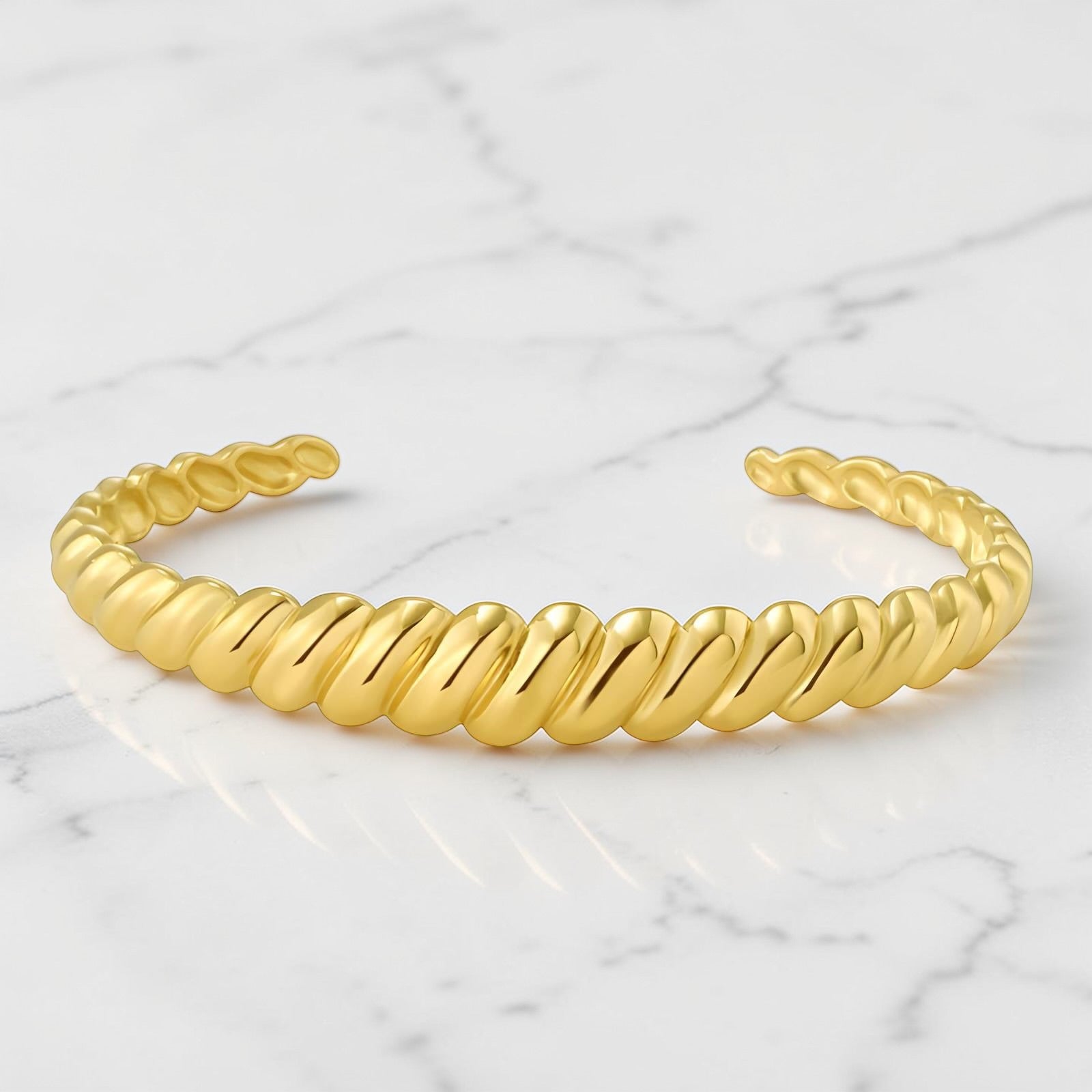 Gold twisted rope-style cuff bracelet with a polished open-ended design.