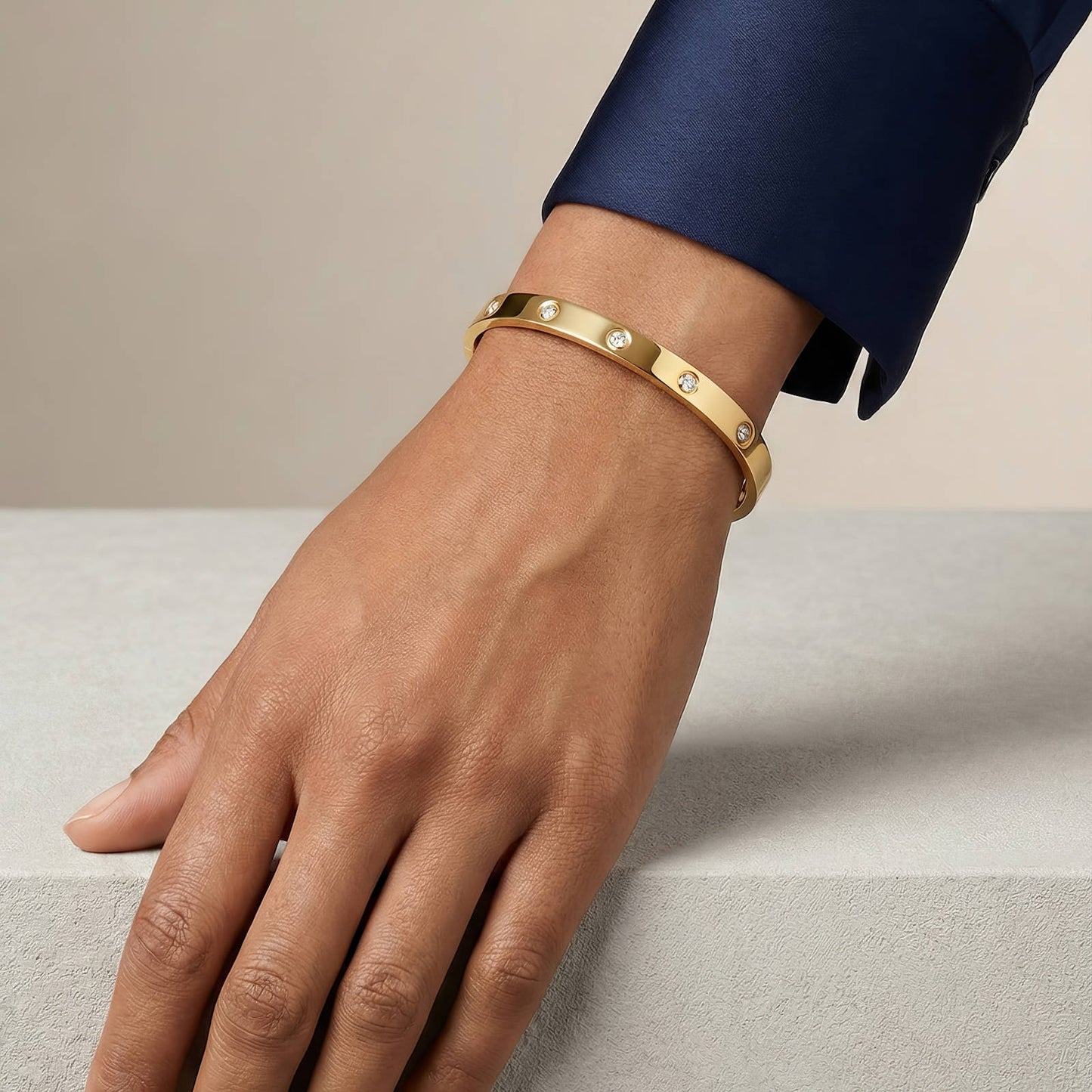 Gold-toned bangle bracelet featuring a sleek design with evenly spaced crystal accents.