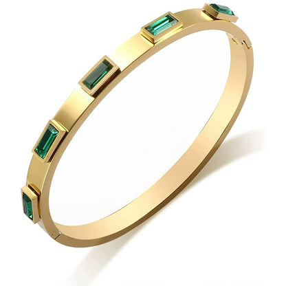Gold bangle bracelet with emerald green rectangular stones by Rayka & Co.