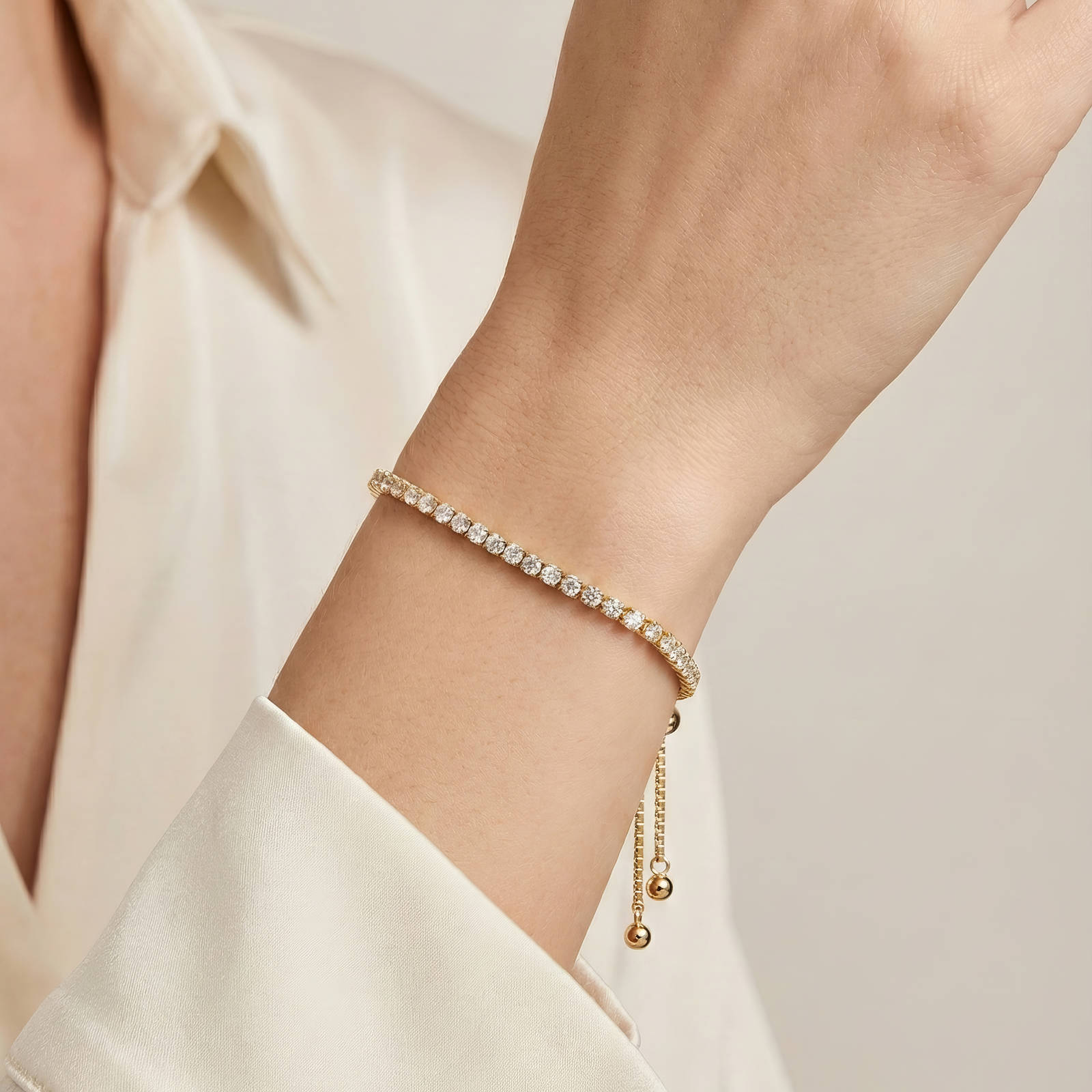 Gold adjustable bracelet with a slim row of clear crystals set along the chain