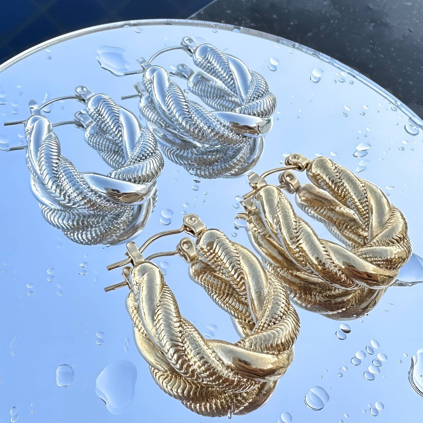 Gold twisted rope hoop earrings with textured detailing and hinged closure